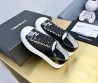 Женские кожаные кеды Chanel 2024 черные лакированные с золотистым значком