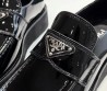 Женские кожаные лоферы Prada черные лакированные на толстой подошве 2024