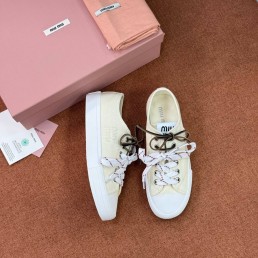 Женские текстильные кеды Miu Miu светло-желтые с разноцветными шнурками 2025